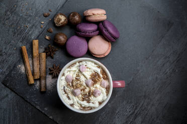 Hot chocolate topped with marshmallows and cream, macaroons, cinnamon sticks, star anise - ISF23872