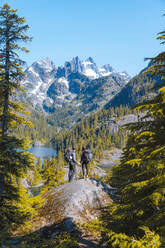 Hikers enjoying view on rock, Alpine Lakes Wilderness, Washington, USA - ISF23881