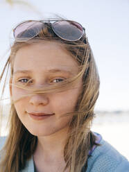 Portrait of smiling girl with tousled hair against sky - MASF16782