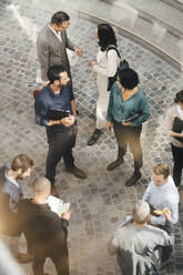 High angle view of male and female business people standing outdoors - MASF16828