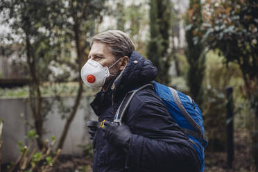 Matuer man commuting in the city, wearing protective mask - MFF05066