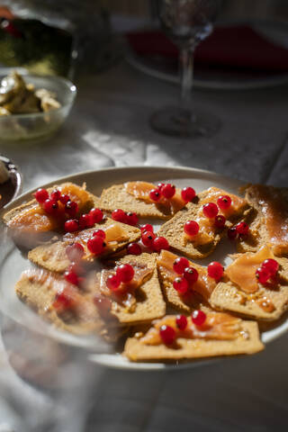 Spanien, Tablett mit Knäckebrot, rohem Lachs und Johannisbeeren, lizenzfreies Stockfoto