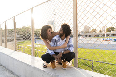 Happy couple at a wire mesh fence - AFVF05480