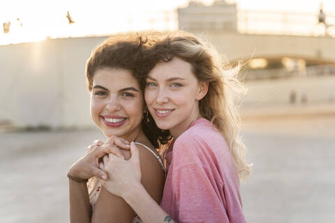 Portrait of smiling friends outdoors at sunset stock photo