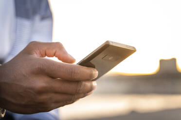 Nahaufnahme eines Mannes, der im Freien ein Smartphone benutzt - AFVF05504