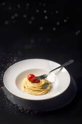 Teller mit Spaghetti und Kirschtomaten mit beleuchtetem Hintergrund - CAVF75882