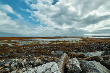 Scenic view of the rocky coast of inishmore during low tide - CAVF75906