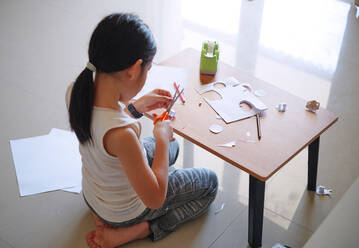 A girl sitting and doing crafts - CAVF75956