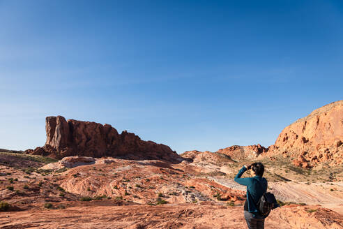 Woman Looking with binoculars out into the desert landscape - CAVF75981