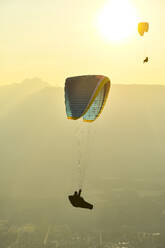 Gleitschirmflieger als Silhouette bei Sonnenuntergang - CAVF76045