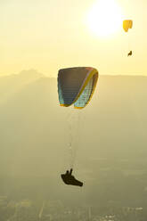 Paragliders silhouetted flying at sunset - CAVF76045