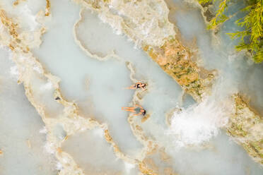 Luftaufnahme von zwei Frauen im Wasser in Terme di Saturnia, Provinz Grosseto, Italien - AAEF06785