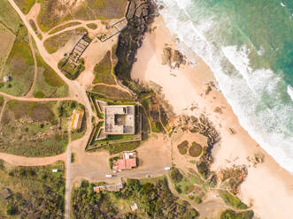 Aerial view above of Forte Pessegueiro on the shore of the beach, Sines, Portugal - AAEF06842