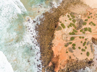 Luftaufnahme von starken Wellen, die am Praia da Bordeira, Carrapateira, Portugal, auf die Küste treffen - AAEF06856