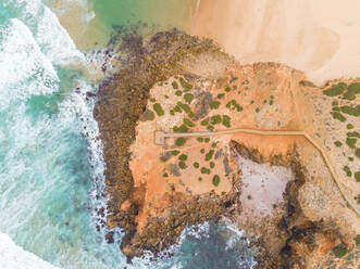 Luftaufnahme von starken Wellen, die am Praia da Bordeira, Carrapateira, Portugal, auf die Küste treffen - AAEF06857