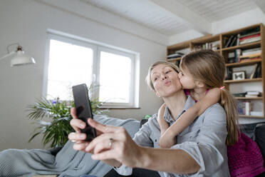 Mutter und kleine Tochter machen Selfie mit Smartphone zu Hause - VYF00009