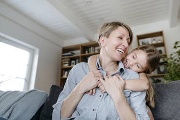 Porträt einer glücklichen Mutter und ihrer kleinen Tochter, die sich gemeinsam zu Hause amüsieren - VYF00010