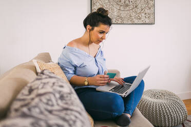 Junge Frau beim Online-Einkauf zu Hause - DCRF00072