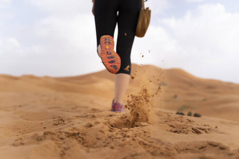 Füße einer Frau, die auf einer Sanddüne in der Wüste Sahara läuft, Merzouga, Marokko - AFVF05526