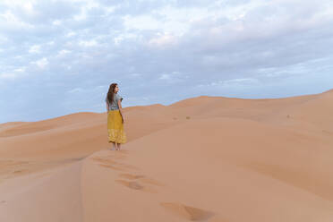 Young woman on sand dune in Sahara Desert, Merzouga, Morocco - AFVF05533