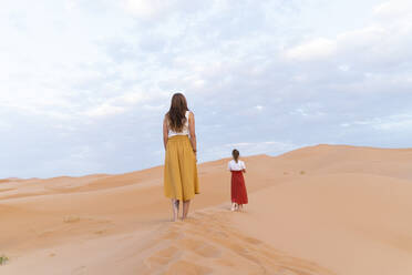 Rückansicht zweier junger Frauen auf einer Sanddüne in der Wüste Sahara, Merzouga, Marokko - AFVF05538