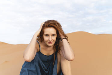 Porträt einer lächelnden rothaarigen jungen Frau in der Wüste Sahara, Merzouga, Marokko - AFVF05547