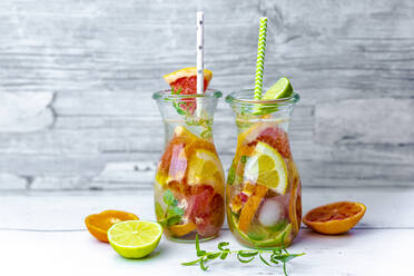 Jars of infused water with various citrus fruits, mint and rosemary - SARF04480