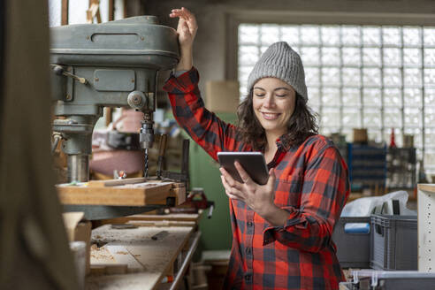 Handwerkerin mit Tablet in ihrer Werkstatt - MOEF02807