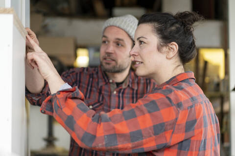 Craftswoman and craftsman discussing in their workshop stock photo