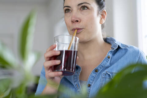 Portrait of woman having a drink using wooden straw stock photo