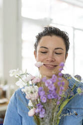Porträt einer lächelnden Frau mit Blumenstrauß - MOEF02864