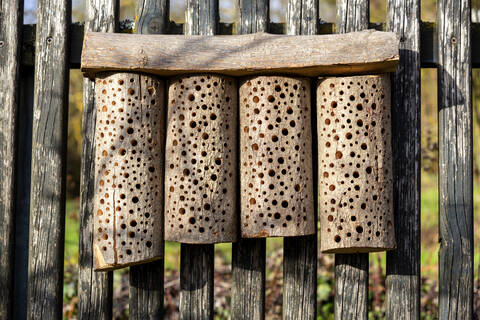 Selbstgebautes Bienenhotel auf einem Holzzaun, lizenzfreies Stockfoto