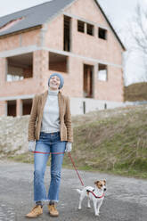 Porträt einer glücklichen reifen Frau, die mit ihrem Hund Gassi geht - VYF00021