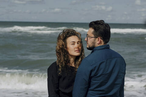 Couple standing in front of the sea stock photo