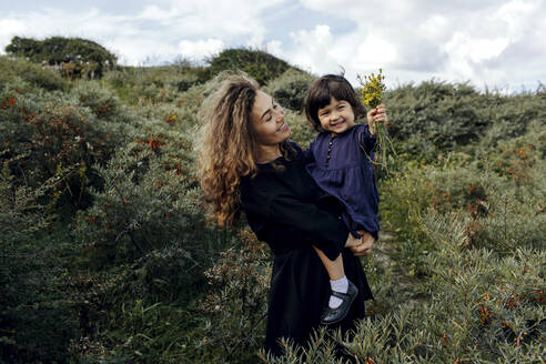 Happy mother and little daughter with picked flowers in nature, The Hague, Netherlands - OGF00183