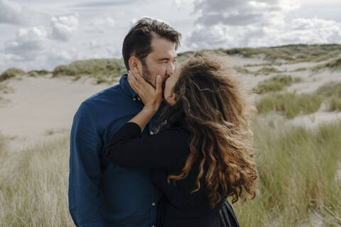 Woman kissing her husband in the dunes, The Hague, Netherlands stock photo