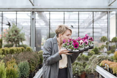 Lächelnde Frau mit Stiefmütterchen im Blumenladen - VYF00024