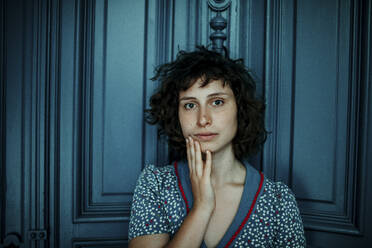 Porträt einer jungen Frau vor einer blauen Holztür - OGF00199