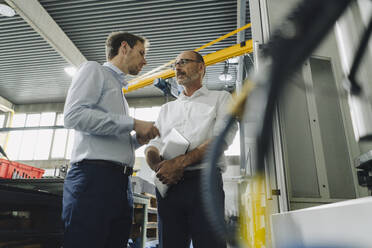 Two men talking in a factory - KNSF07721