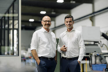 Portrait of two confident businessmen in a factory - KNSF07731
