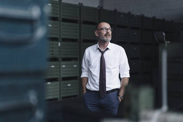 Portrait of a businessman in a factory looking away - KNSF07736