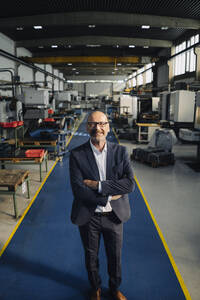 Porträt eines lächelnden Geschäftsmannes in einer Fabrik - KNSF07789