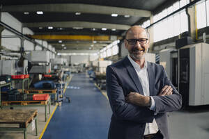 Porträt eines lächelnden Geschäftsmannes in einer Fabrik - KNSF07791