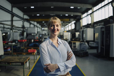 Portrait of a smiling businesswoman in a factory - KNSF07793