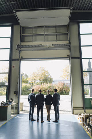 Rückansicht eines Wirtschaftsteams, das am Werkstor steht, lizenzfreies Stockfoto