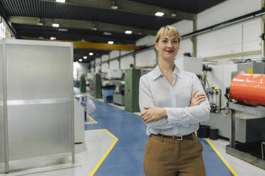 Portrait of a confident businesswoman in a factory - KNSF07826