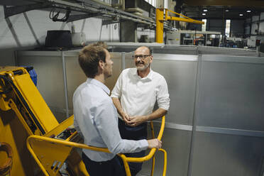 Two men talking in a factory - KNSF07864