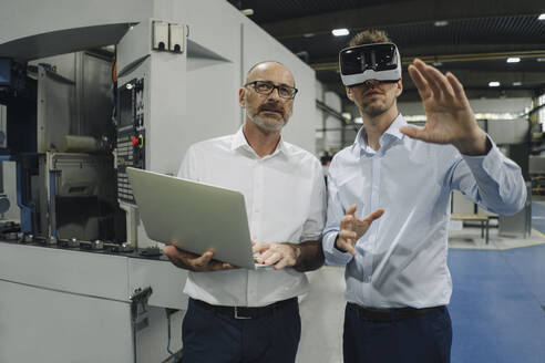 Two men with VR glasses in factory - KNSF07871