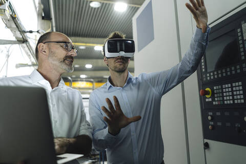 Zwei Männer mit VR-Brille in einer Fabrik, lizenzfreies Stockfoto