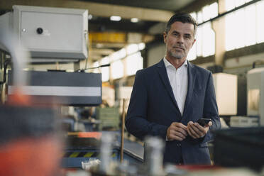 Portrait of a confident businessman in a factory - KNSF07898